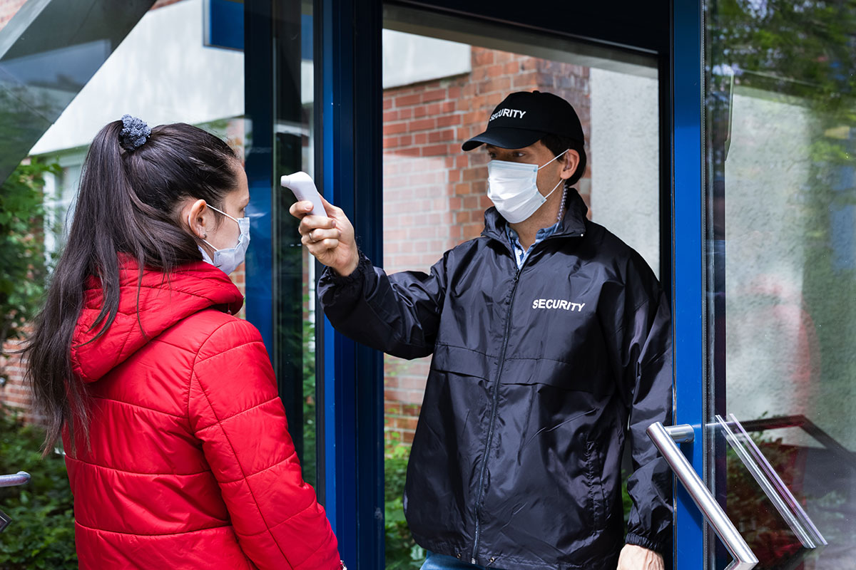 Masked Security Guard Checking Temperature