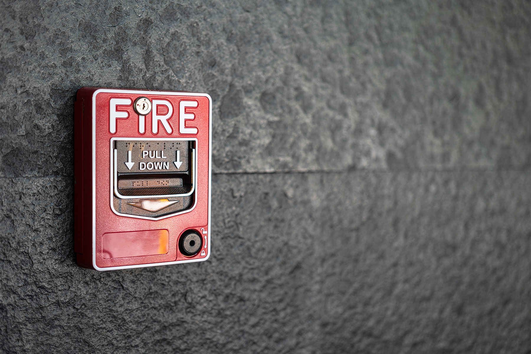 Fire alarm trigger mounted on the wall of an office building for fire safety